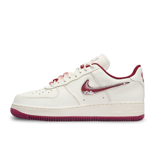 Side view of Nike Air Force 1 Valentine's Day 2024 with white and off-white upper, featuring pink and red accents and a bubble Swoosh filled with confetti.