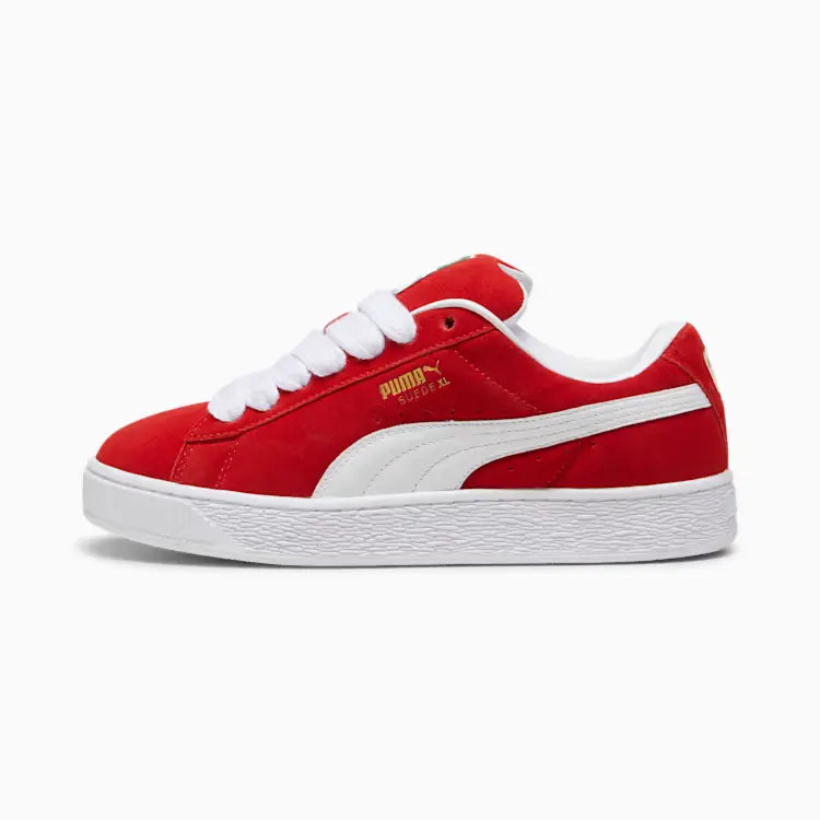 Red suede Puma Suede XL sneakers with white laces and a white rubber sole, featuring gold Puma branding on the side.